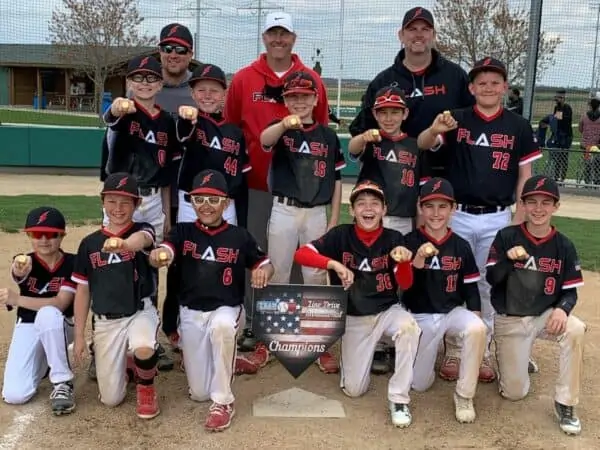 11U Flash baseball team with coaches wearing championship rings holding a home plate for Line Drive tournament