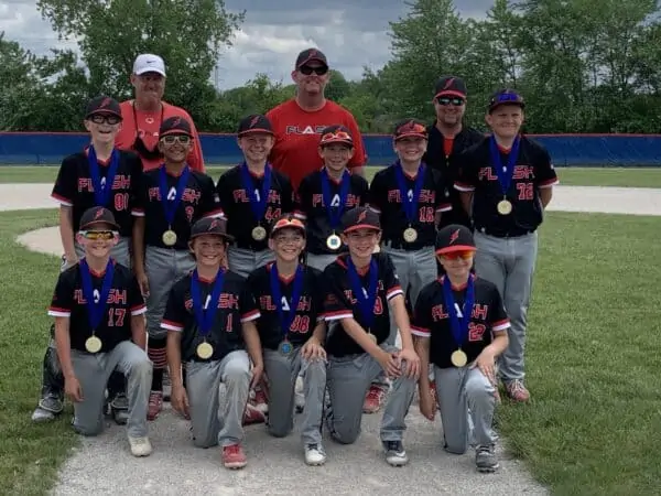 11 U boys Flash baseball team and coaches kneeling for Ho Chunk Slamfest wearing championship medals